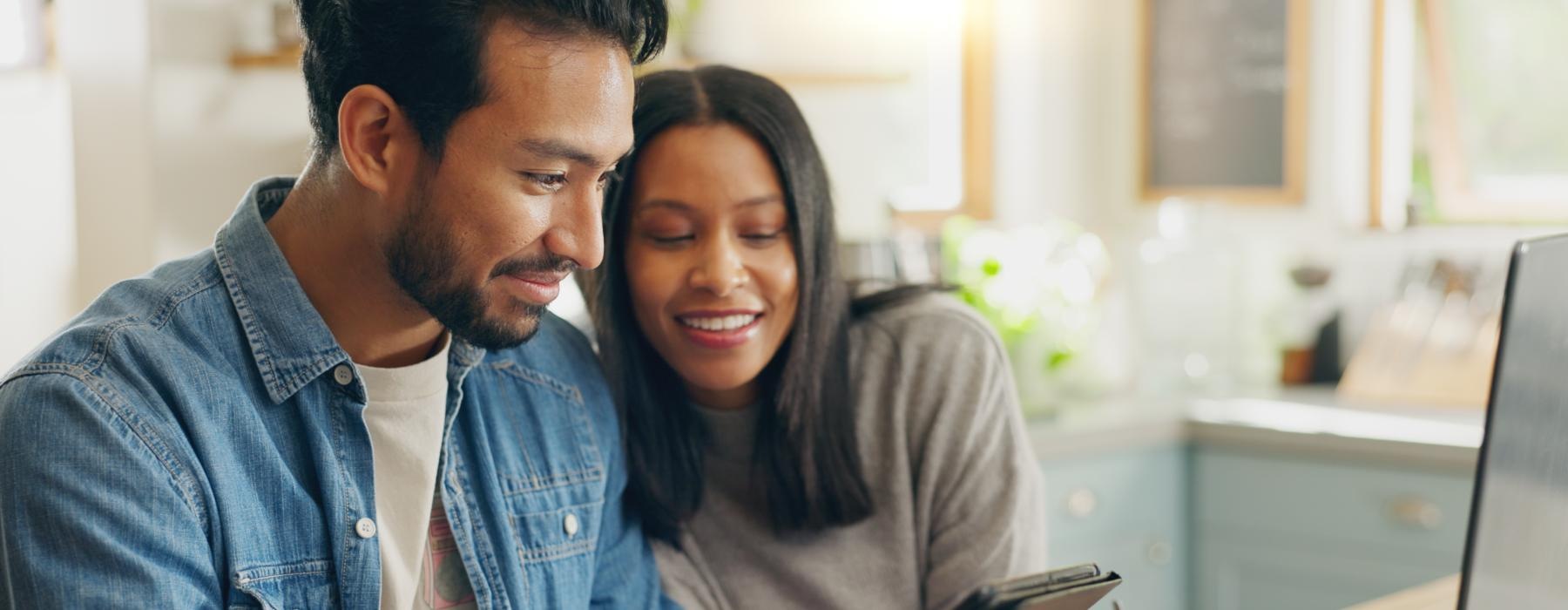 a man and a woman looking at a laptop